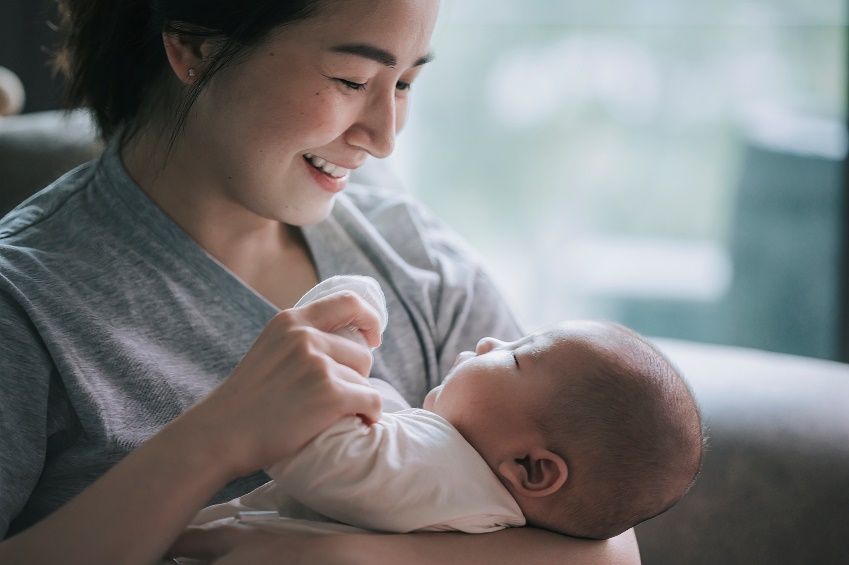 A person holding a baby
Description automatically generated
